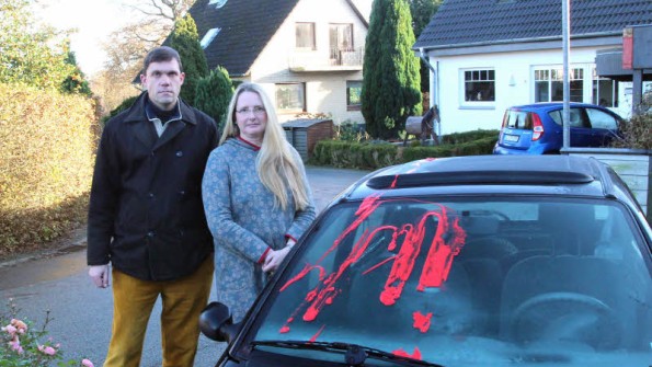 Kerstin und Frank Hansen vor dem farbverschmierten Zweitwagen der Familie. 