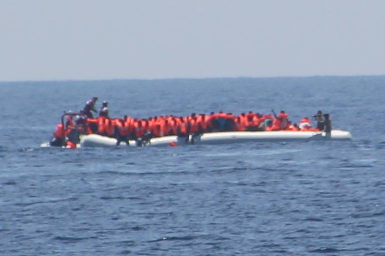 Schlauchboot mit zwei bewaffneten Menschen