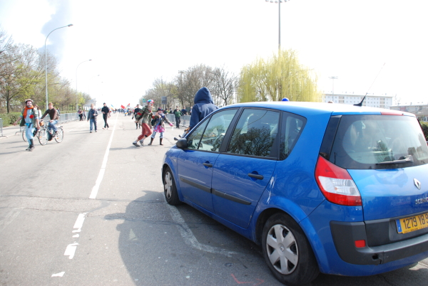 La voiture de police (immatriculée 1279 YB 94) fonce avec un-e activiste sur le capot.