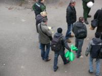 Hier transportieren die Beamten beschlagnahmte Gegenstände in zwei Plastiksäcken ab.