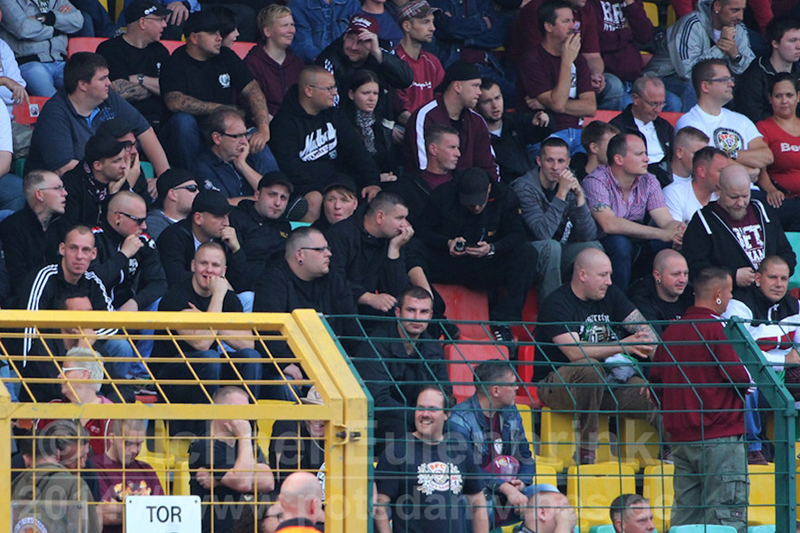 David Linke zusammen mit Zahlreichen Mitgliedern des NW-Berlin. Bildmitte: Stützt das Kin auf. (20.09.2014, BFC gegen Babelsberg 03, Janhsportpark Prenzlauer berg)