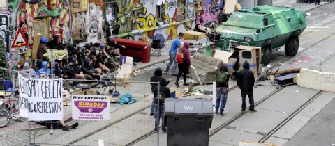 Mit einem Panzerwagen, Wasserwerfern und 1700 Beamten geht die Polizei in Wien gegen Hausbesetzer vor.