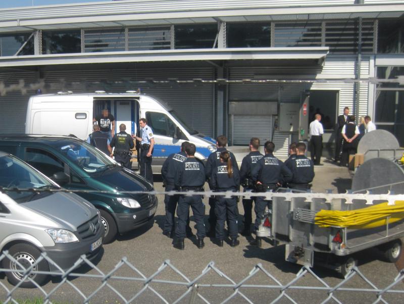 Ein Mensch wird aus einer Einzelzelle zum Check-in geführt