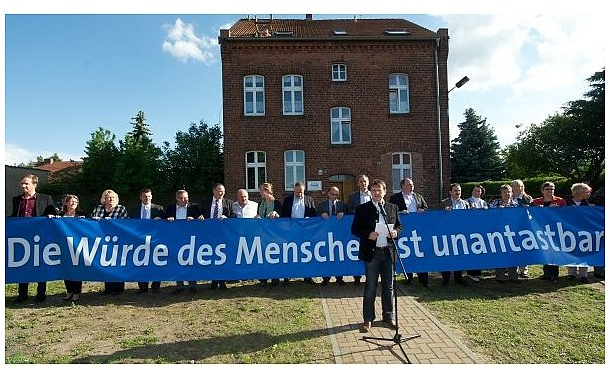 Antifa-Aktivisten liefern sich während der Rede des Landtagspräsidenten mit Polizisten eine Rangelei um ein Plakat. | Foto: B. Kaufholz