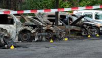 Wracks ausgebrannter Autos stehen auf einem Parkplatz hinter Absperrband. Die Fahrzeuge wurden in der Nacht von unbekannten Tätern angezündet