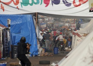 14 August 2013, security officer firing tear gas on protesters as they attempt to escape the attacks by the security apparatus. Image originally posted to Flicker by tarek1991